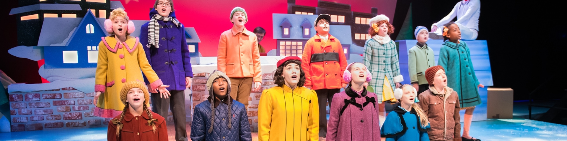 a group of children singing on a stage
