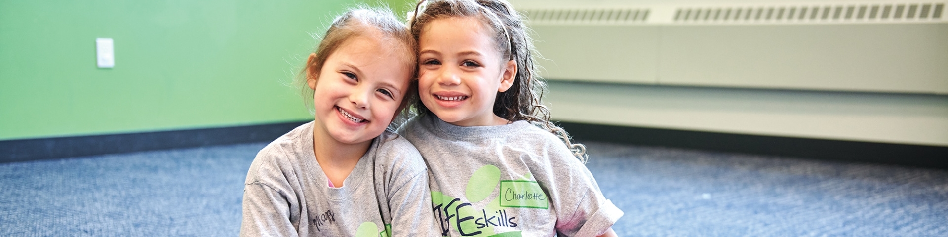 two girls smiling at the camera